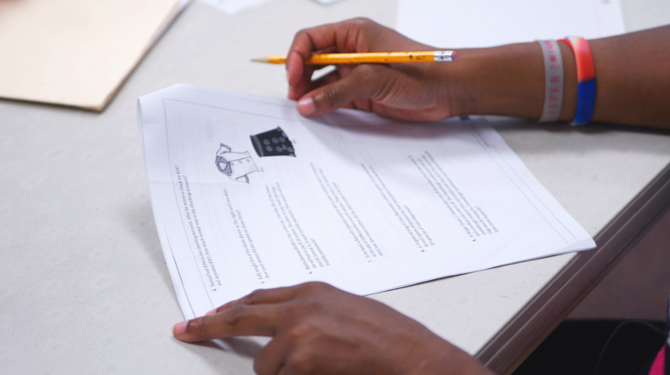 A GED student works on a packet