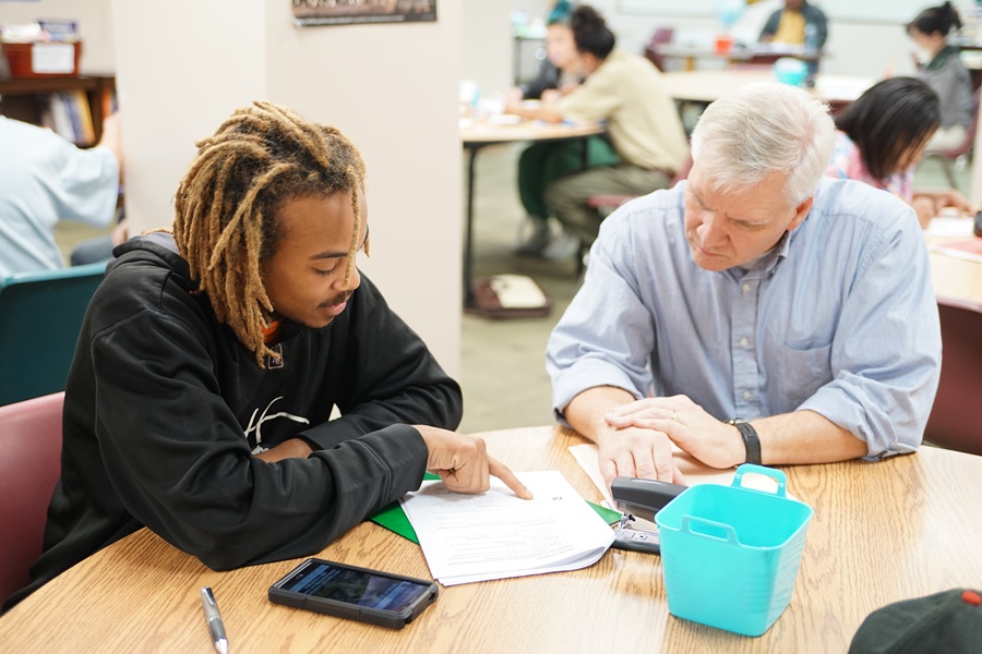 A tutor helps an evening GED student.