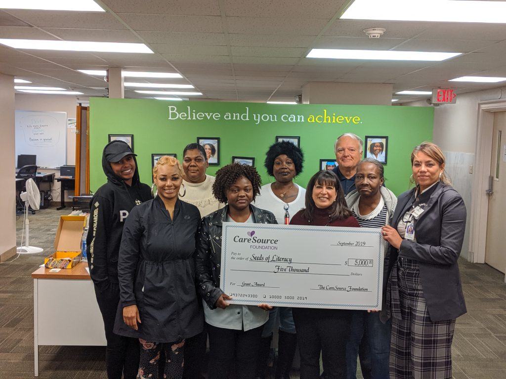 CareSource Community Marketing Representative Eliduvina Aponte, far right, presented a ceremonial $5,000 check to Seeds of Literacy President and CEO Bonnie Entler, Chairman of the Board George Miller and several Seeds of Literacy students at Seeds West, 3104 W. 25th St. in Cleveland, on Nov. 14. 